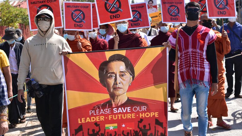 Протестующие несут плакат в поддержку Аун Сан Су Чжи