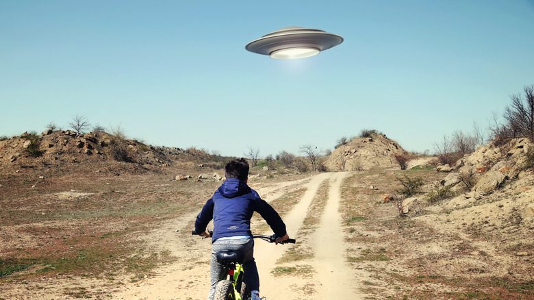 Ребенок едет на велосипеде в сторону НЛО