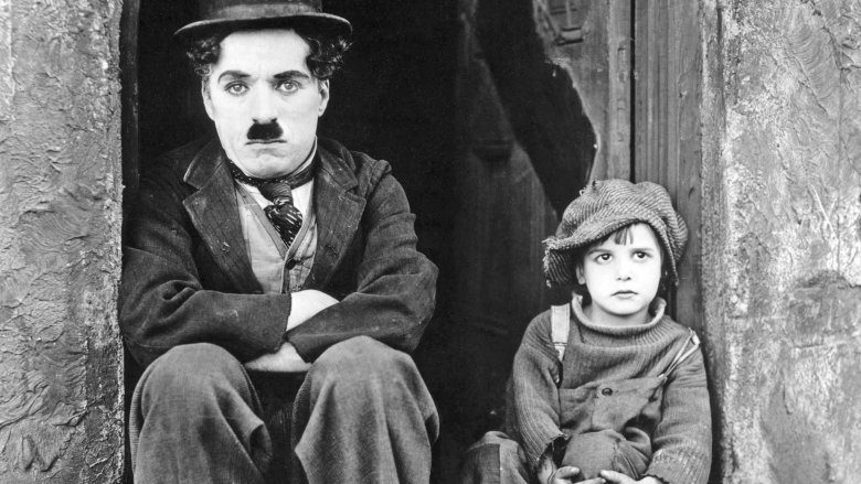 Чарли Чаплин сидит в дверном проеме