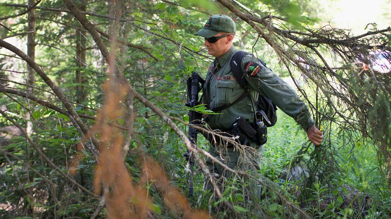 Полицейский обыскивает лес