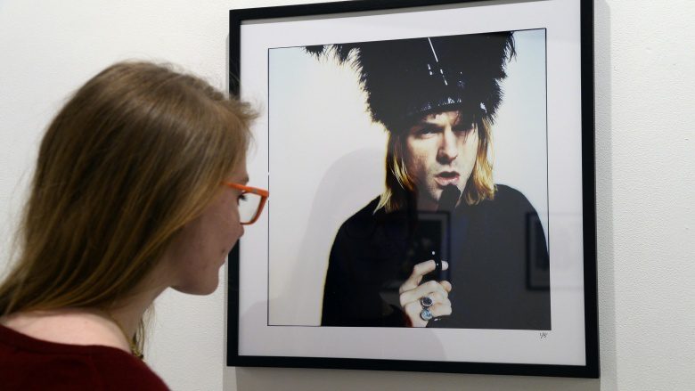 женщина смотрит на фотографию Курта Кобейна
