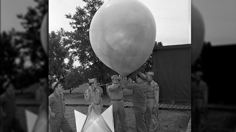 Пять летчиков прикрепляют радарное устройство к метеорологическому шару