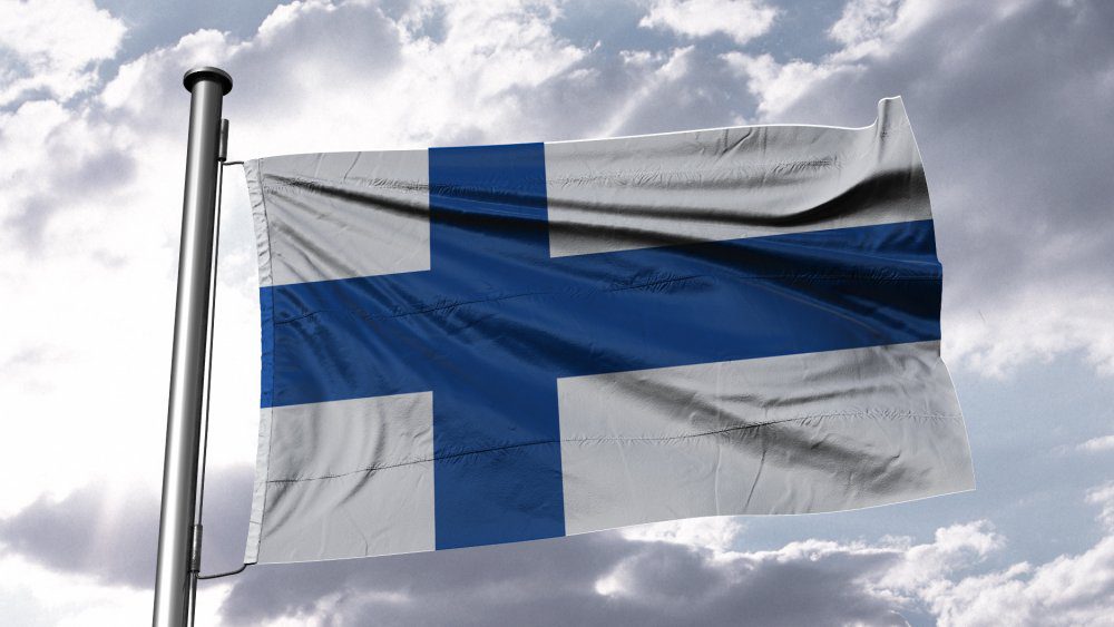 Финский флаг развевается на ветру в голубом небе