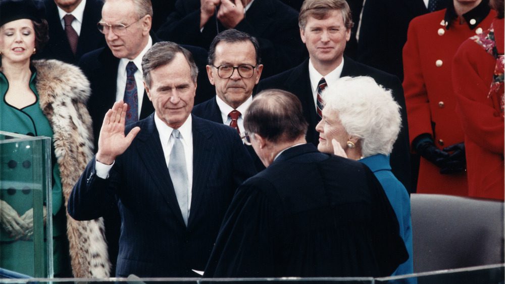 Председатель Верховного суда Уильям Ренквист приносит присягу президенту Джорджу Бушу во время церемонии инаугурации в Капитолии США. 20 января 1989 года