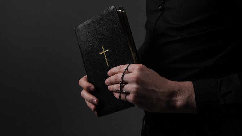 Библия в руках священника
