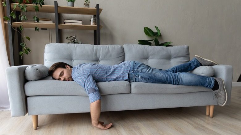 мужчина засыпает на диване