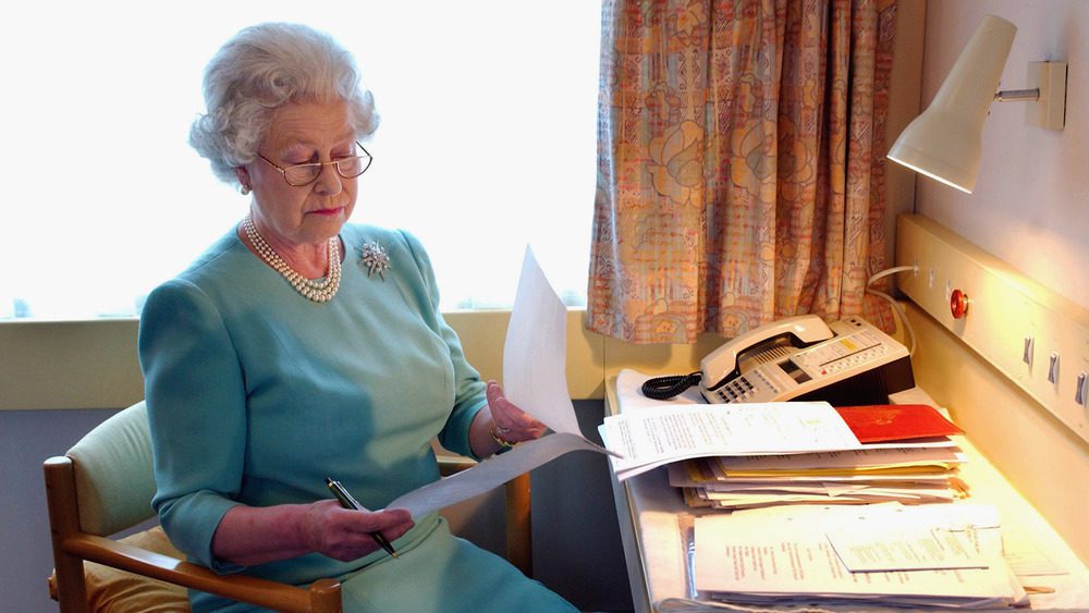 Королева Елизавета II работает за своим столом в Королевском поезде в мае 2002 года.