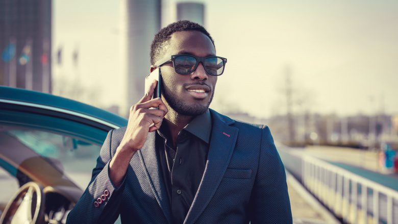 стильный черный мужчина с мобильным телефоном
