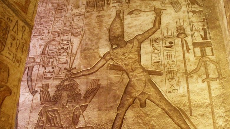 Резьба, изображающая древнеегипетского фараона, казнящего человека