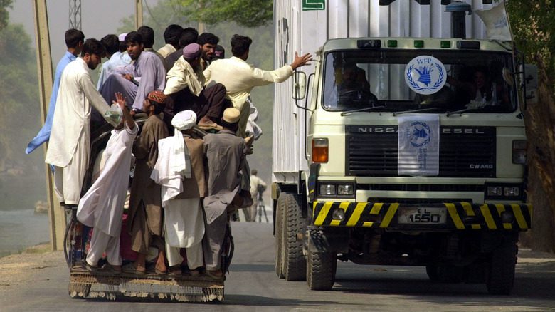 Беженцы проходят мимо грузовика с продовольственной помощью в Афганистане 