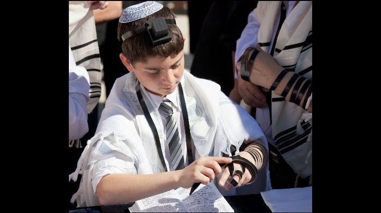 Еврейский мальчик надевает тфиллин