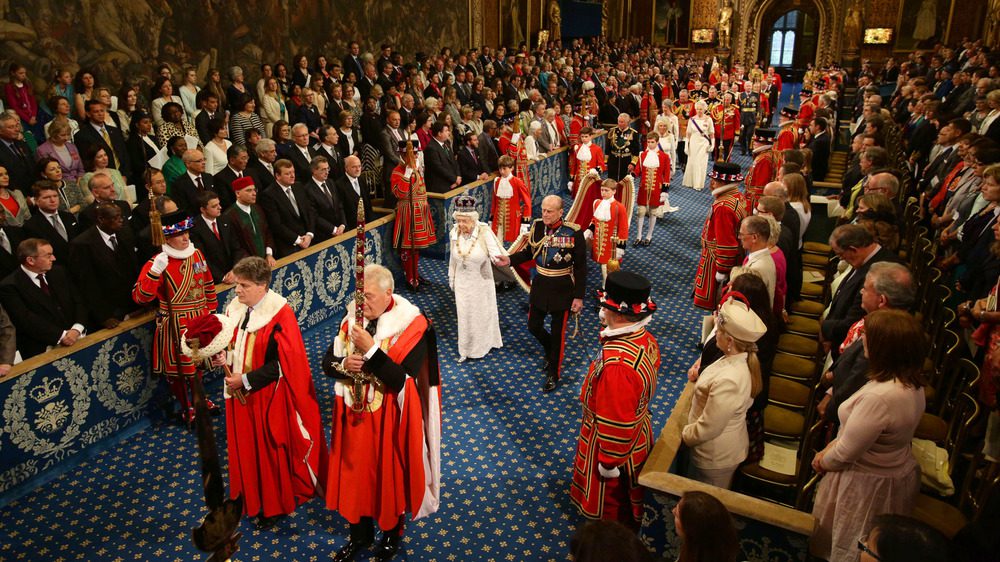Королева Елизавета II и принц Филипп, герцог Эдинбургский, проходят через Королевскую галерею во время государственного открытия парламента в Палате лордов в Вестминстерском дворце 4 июня 2014 года в Лондоне, Англия.