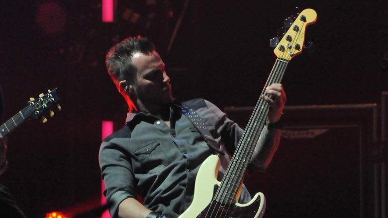Брайан Маршалл играет на бас-гитаре на сцене
