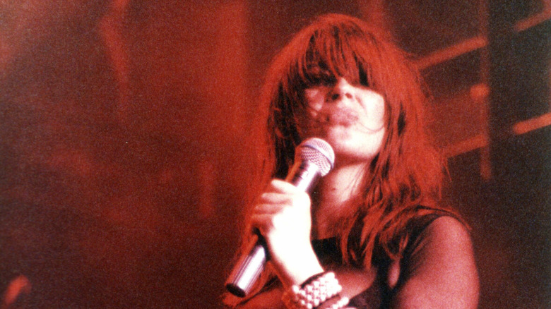 Крисси Амфлетт с рыжими волосами поет в микрофон