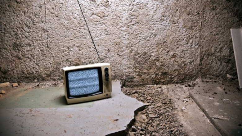 Маленький телевизор на разбитом бетоне