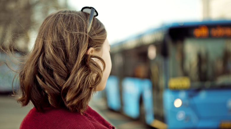 Женщина смотрит на синий автобус