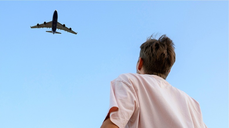 Человек смотрит вверх на самолет