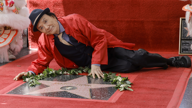 Джеймс Хонг в красной рубашке лежит на голливудской Аллее славы