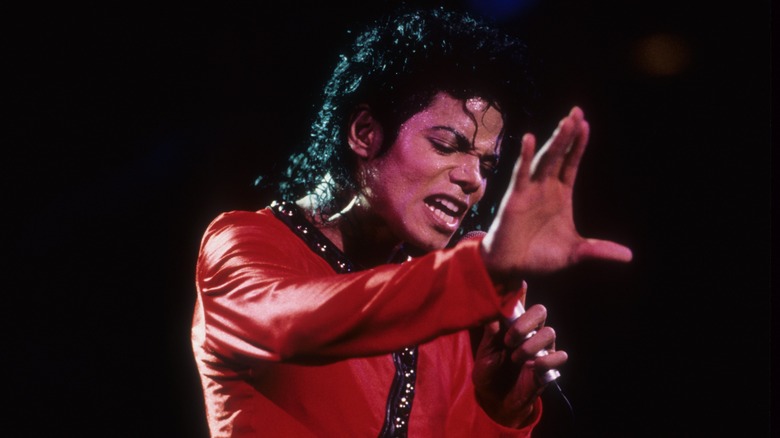 Майкл Джексон в красном костюме выступает на сцене
