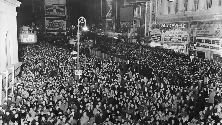 Толпы людей собираются на затемненной Таймс-сквер