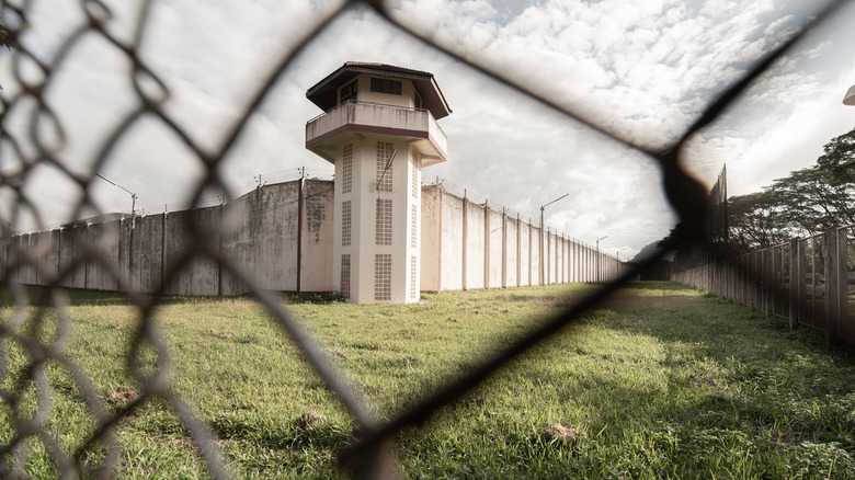 Тюремная башня за оградой из цепей
